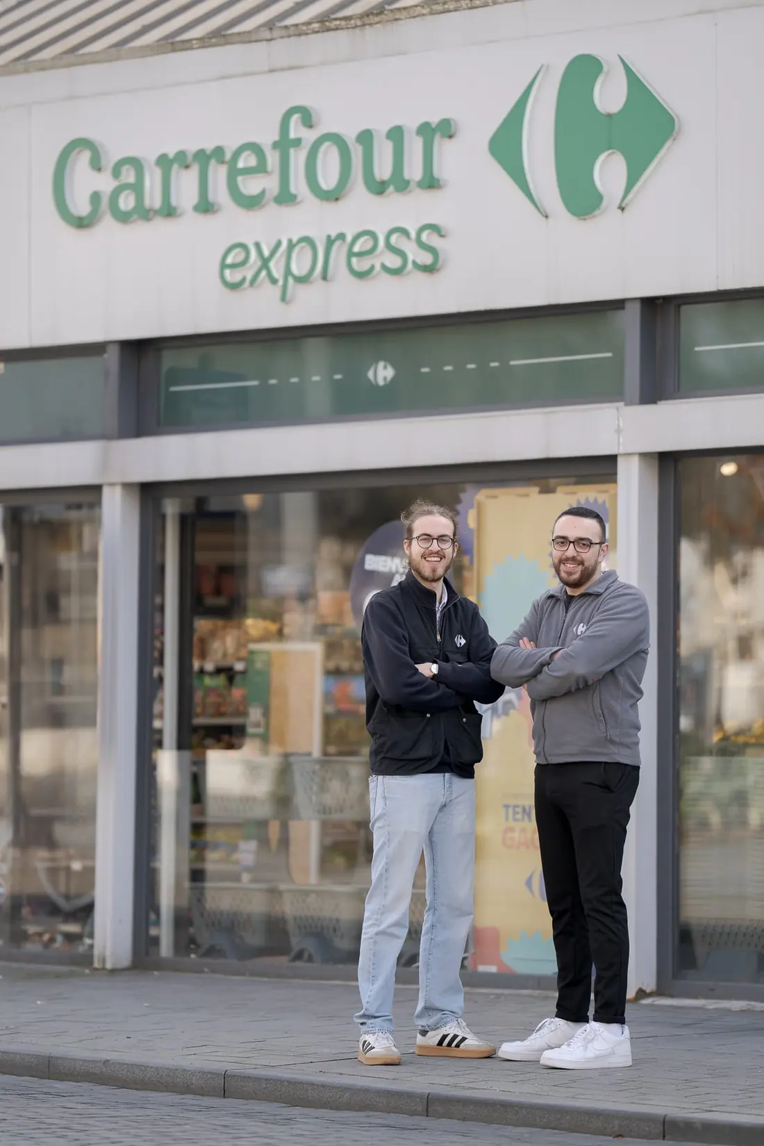 Deux franchisés devant la devanture de leur magasin Carrefour Express à Tours